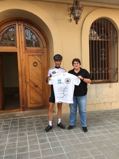 Un ciclista que recorre la ruta de la Orden de Montesa haceparada en el Ayuntamiento de Les Coves de Vinromà