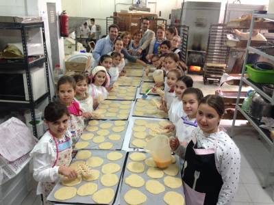 Las reinas de las fiestas visitan la panadera donde se elaboran las coquetas de Sant Antoni