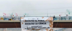 Activistes pengen del Pont Solidari per reclamar solucions contra la crisi ecosocial